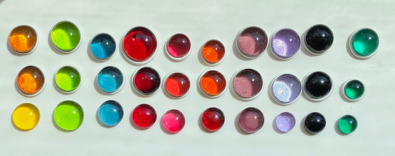 various colored/sized glass cabochons in sunlight