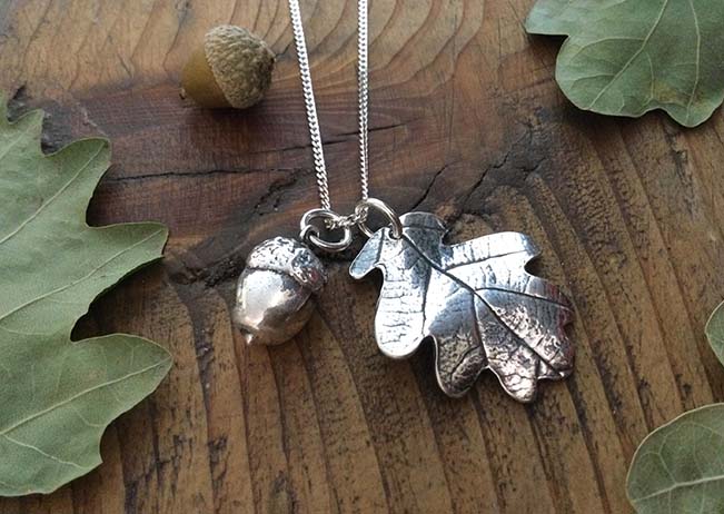 art clay silver leaf and acorn charms on wood