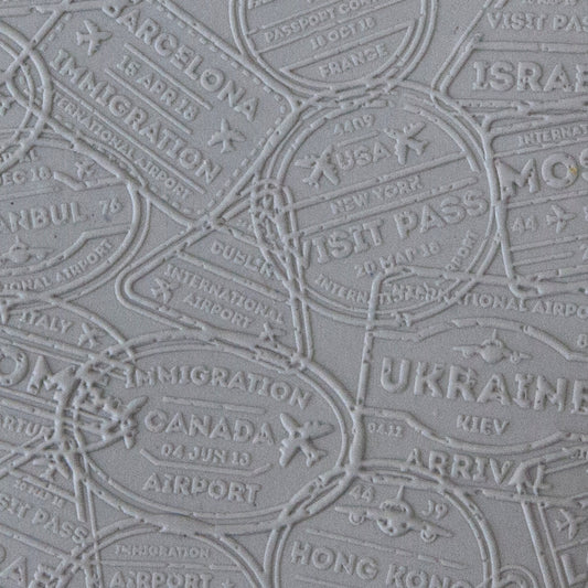 sample in clay of Mega Texture Tile - Bon Voyage Embossed. Use to impress texture in soft clays. Mega Texture Tiles are perfect for projects both large and small. Mega Tiles measure 9-1/4" x 6" and are about 7 times larger than Texture Tiles. These textures are flexible, washable and can be used with any soft clay.