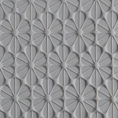 Texture Tile - Retro Daisies sample rolled into gray polymer clay