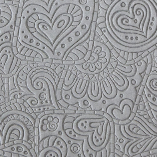 sample in clay of Mega Texture Tile - Doodling Hearts. Use to impress texture in soft clays. Mega Texture Tiles are perfect for projects both large and small. Mega Tiles measure 9-1/4" x 6" and are about 7 times larger than Texture Tiles. These textures are flexible, washable and can be used with any soft clay.