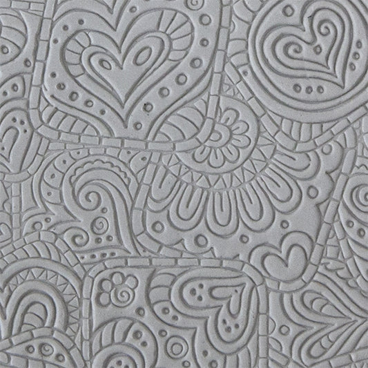 sample in clay of Mega Texture Tile - Doodling Hearts. Use to impress texture in soft clays. Mega Texture Tiles are perfect for projects both large and small. Mega Tiles measure 9-1/4" x 6" and are about 7 times larger than Texture Tiles. These textures are flexible, washable and can be used with any soft clay.