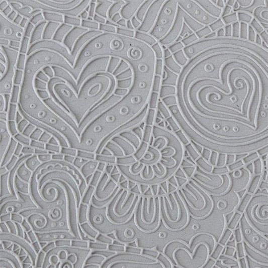 sample in clay of Mega Texture Tile - Doodling Hearts Fineline. Use to impress texture in soft clays. Mega Texture Tiles are perfect for projects both large and small. Mega Tiles measure 9-1/4" x 6" and are about 7 times larger than Texture Tiles. These textures are flexible, washable and can be used with any soft clay.