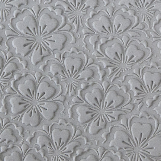 sample in clay of Mega Texture Tile - Flowering Fields. Use to impress texture in soft clays. Mega Texture Tiles are perfect for projects both large and small. Mega Tiles measure 9-1/4" x 6" and are about 7 times larger than Texture Tiles. These textures are flexible, washable and can be used with any soft clay.