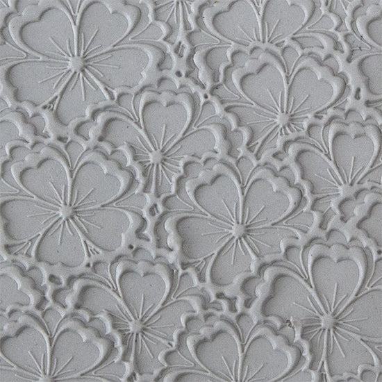 sample in clay of Mega Texture Tile - Flowering Fields Embossed. Use to impress texture in soft clays. Mega Texture Tiles are perfect for projects both large and small. Mega Tiles measure 9-1/4" x 6" and are about 7 times larger than Texture Tiles. These textures are flexible, washable and can be used with any soft clay.