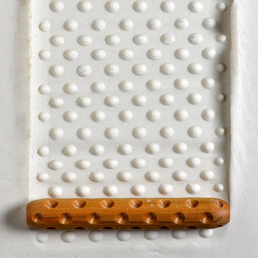 Wooden Hand Roller - Dots rolled into white clay