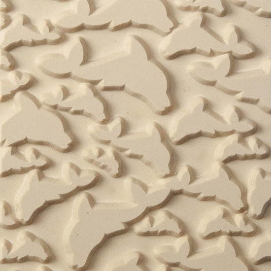 Texture Tile - Flying Dolphins. Beige Texture Tiles are flexible, washable and can be used with any soft clay. Spritz with CoolSlip or dust on Dry Powder Release for stick-free impressions when using metal clay and polymer clay.