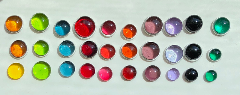 various colored/sized glass cabochons in sunlight 